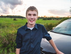 teenager leaning against car